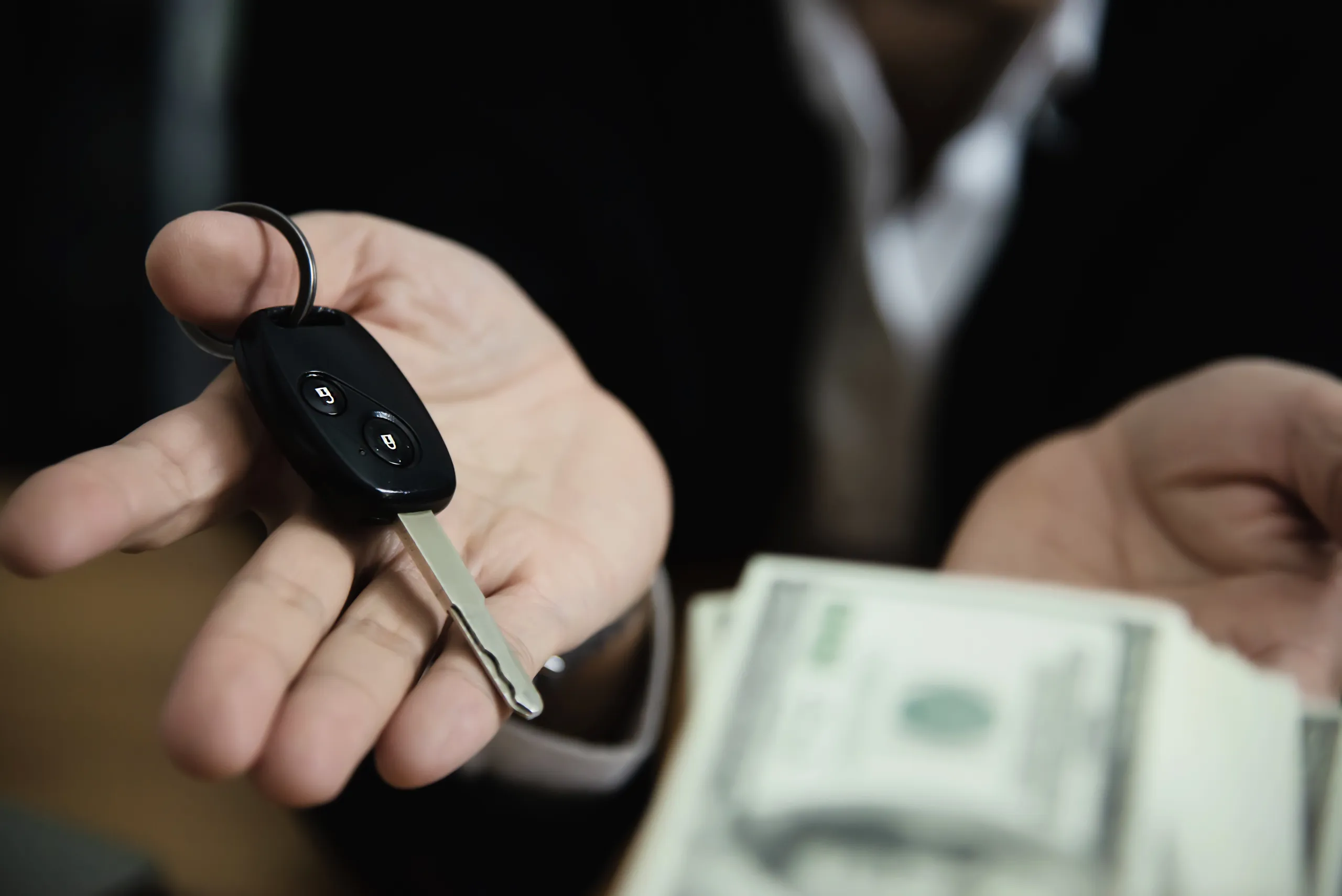 Un hombre entregando unas llaves y recibiendo dinero